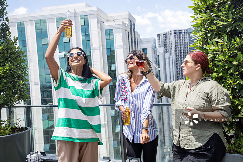 女性在城市屋顶上享用鸡尾酒图片素材