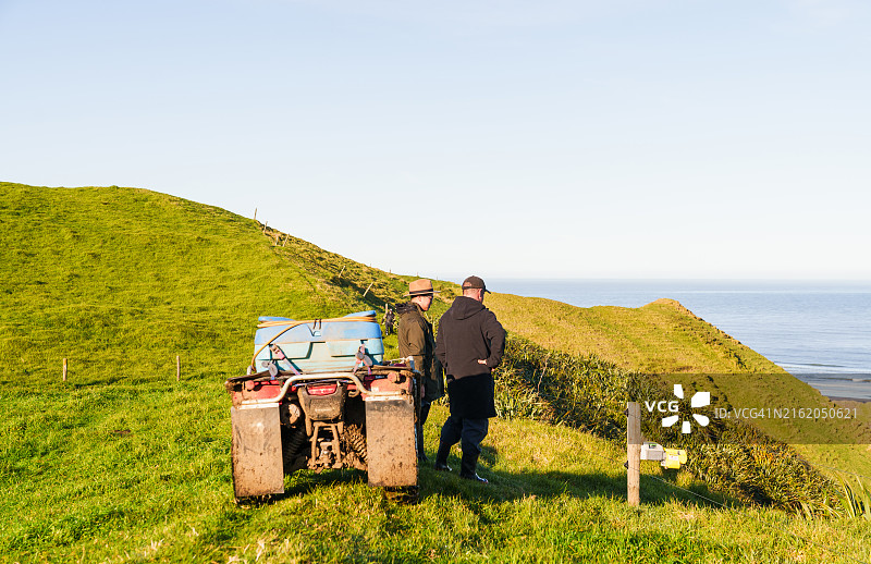 农民骑着四轮摩托车观察自然图片素材