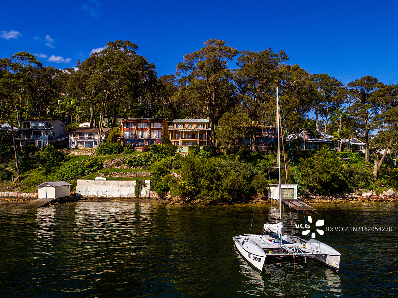 阿瓦隆皮特沃特晴朗的一天，一艘白色帆船停泊在房屋前图片素材