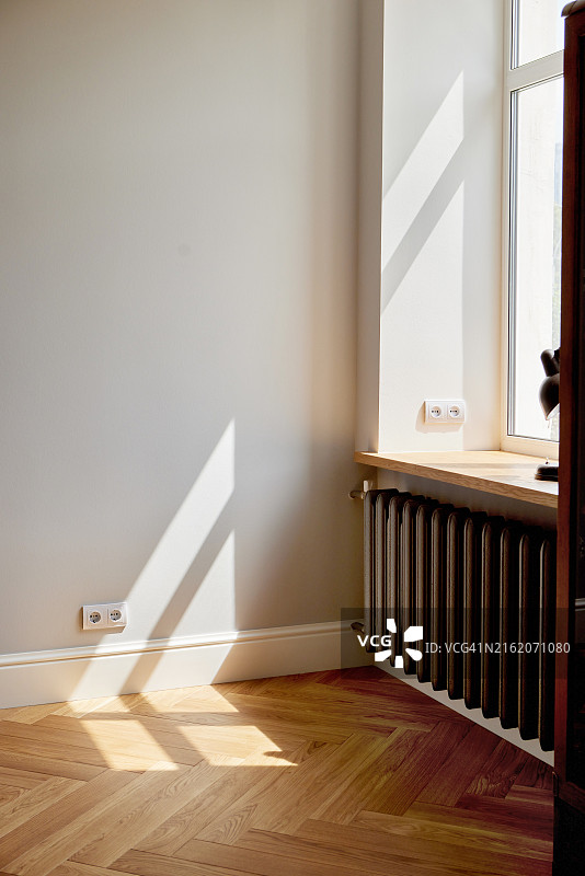 阳光明媚的现代简约房间，配有暖气和木地板图片素材