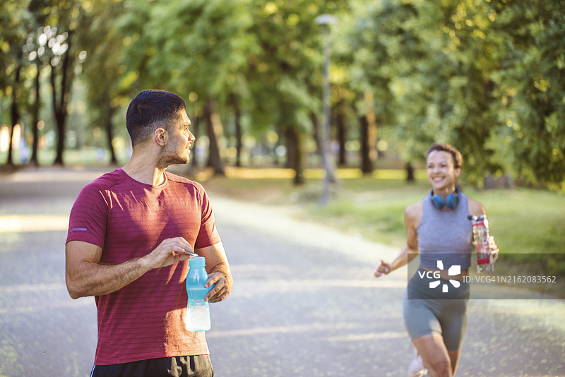 年轻的白人男性运动员在户外活动中休息，补充能量/健康补剂。图片素材