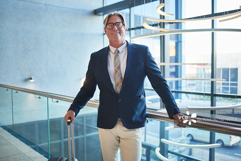 商务旅行中在机场的商人，携带行李箱图片素材