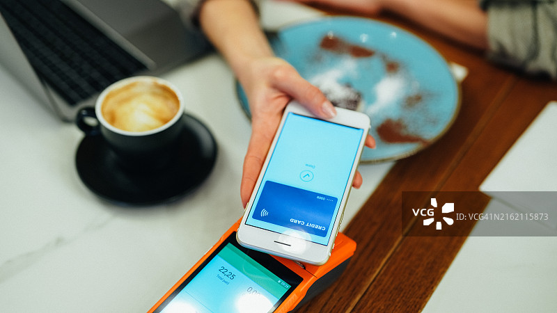 女人在餐厅使用数字钱包进行手机支付图片素材