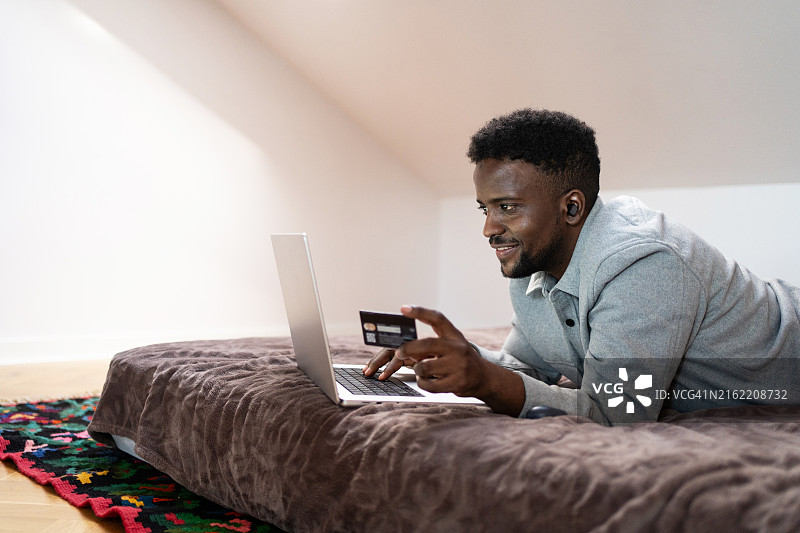 年轻男人在家网上购物图片素材