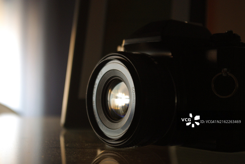 黑暗光线下露出镜头玻璃的单反相机图片素材