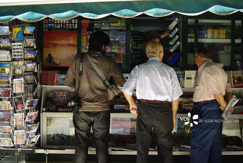 人们在报摊上看报纸图片素材