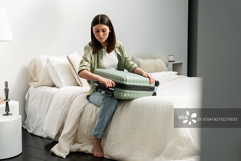 女人收拾行李箱准备出国度假图片素材