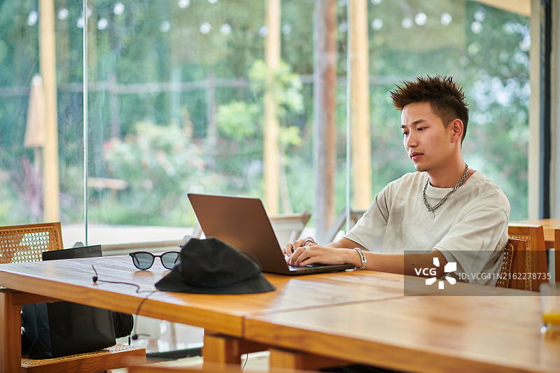 在假期远程办公的亚洲年轻男子图片素材