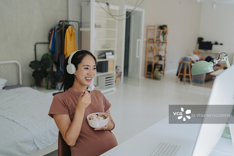 孕妇在家吃早餐和工作图片素材