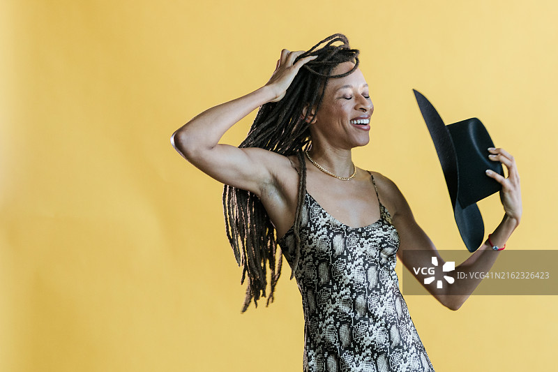 有脏辫的女人拿着牛仔帽图片素材