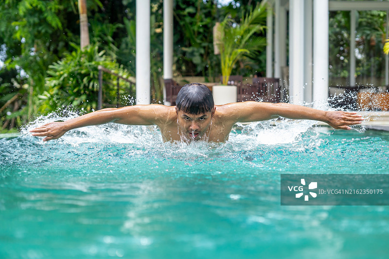 在游泳池里蝶泳的男游泳运动员图片素材