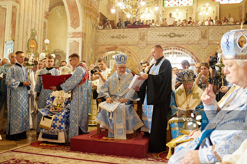 身穿蓝色长袍的神职人员在仪式上坐在宝座上图片素材