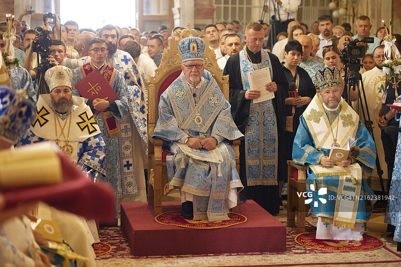 身穿蓝色长袍的神职人员在仪式上坐在宝座上图片素材