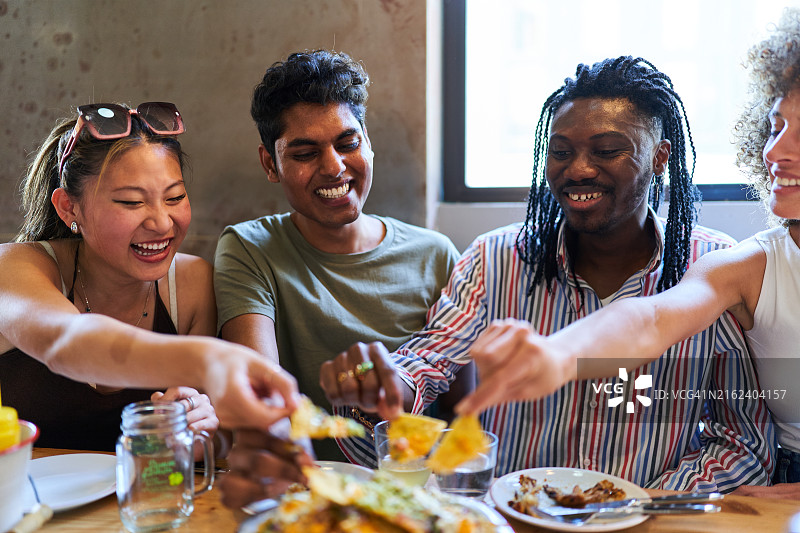 朋友们在墨西哥餐厅分享玉米片图片素材