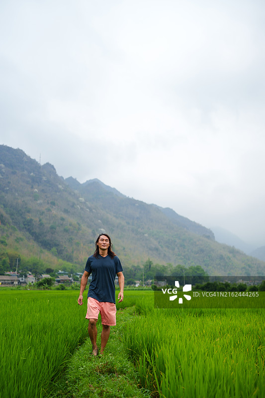 在越南梅州山谷稻田里行走的男人图片素材