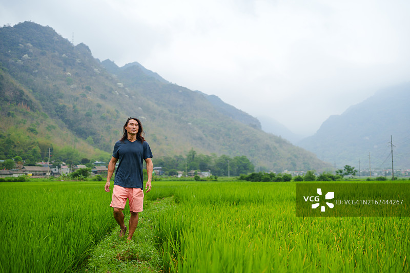 在越南梅州山谷稻田里行走的男人图片素材