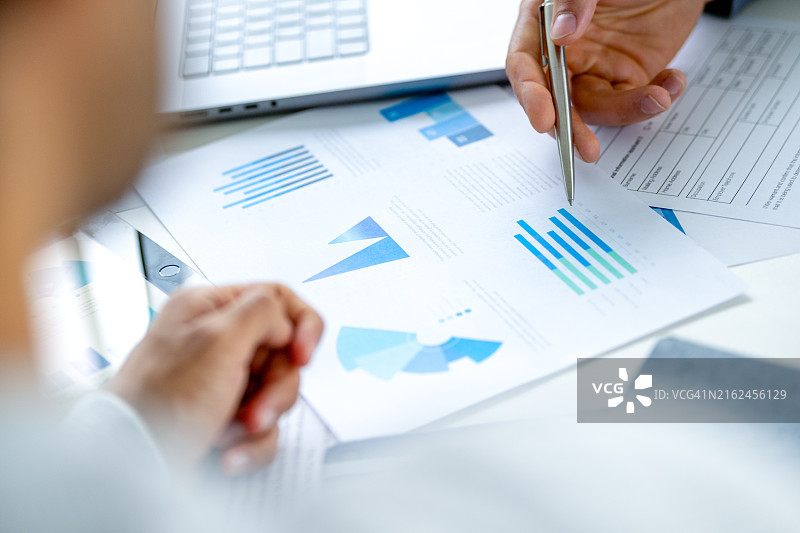 两位商务人士开会查看财务数据和图表文件图片素材