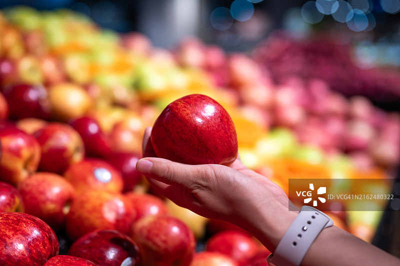 一个新西兰红苹果在女人手中图片素材