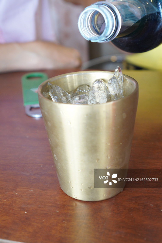 将蓝色夏威夷果汁倒入冰铝杯中图片素材