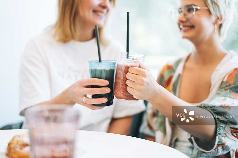 母亲和十几岁的女儿在咖啡馆喝冰沙图片素材