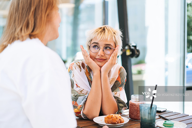 中年妈妈和十几岁的女儿在咖啡馆吃早餐图片素材