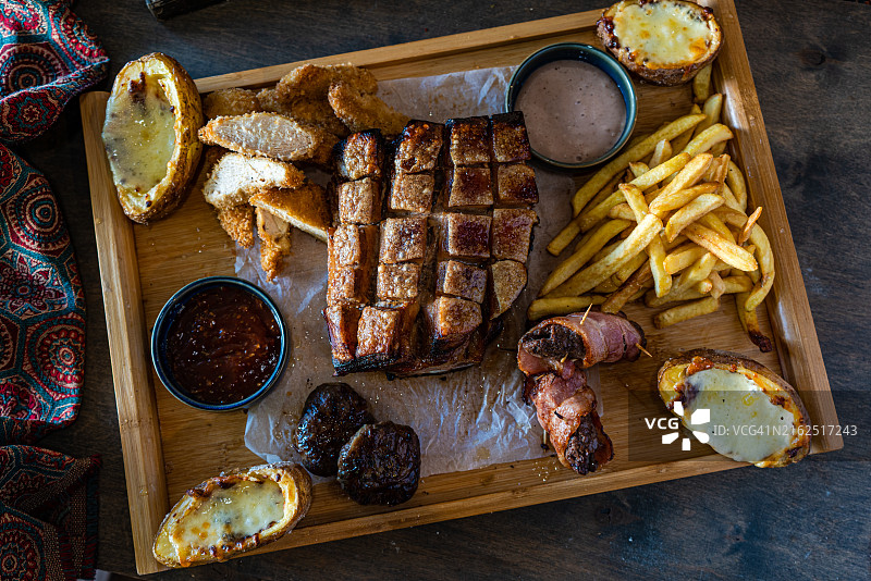 俯视角度拍摄的烤猪肉、炸鸡和奶酪土豆图片素材