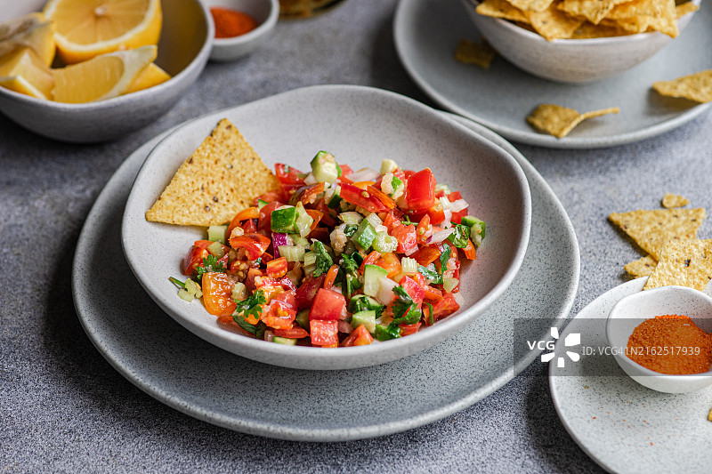 配有玉米饼和鲜柠檬的传统墨西哥Pico de Gallo莎莎酱碗特写图片素材