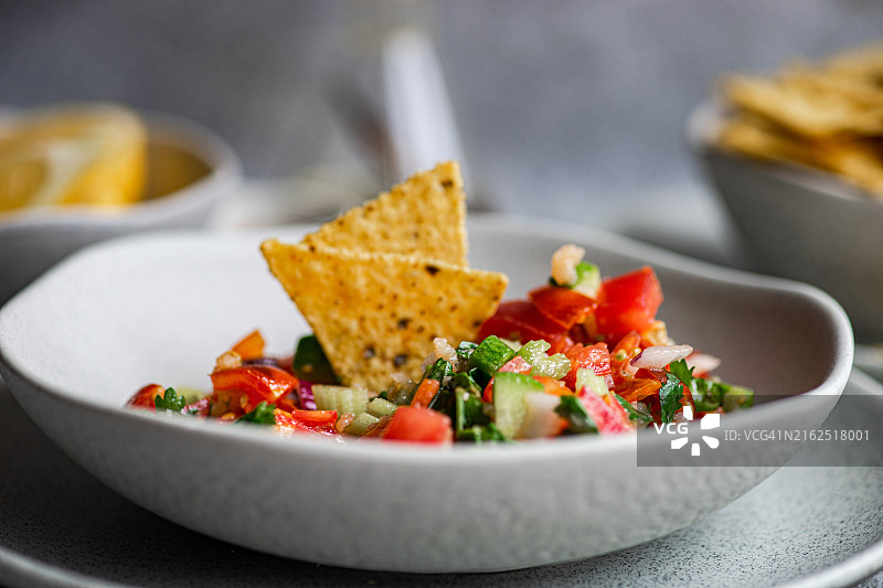 配有玉米饼和鲜柠檬的传统墨西哥Pico de Gallo莎莎酱碗特写图片素材