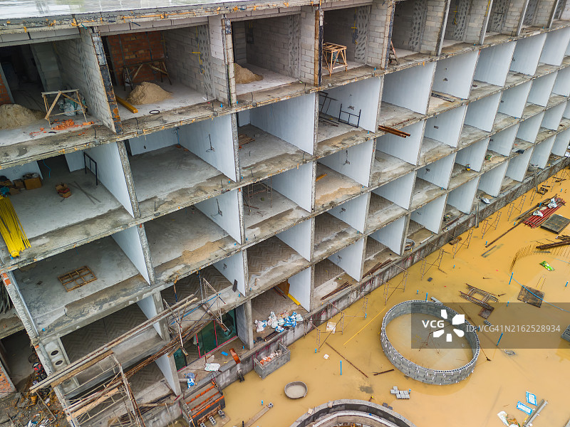 大型建筑工地，建筑物周围竖立着脚手架，有许多工人图片素材