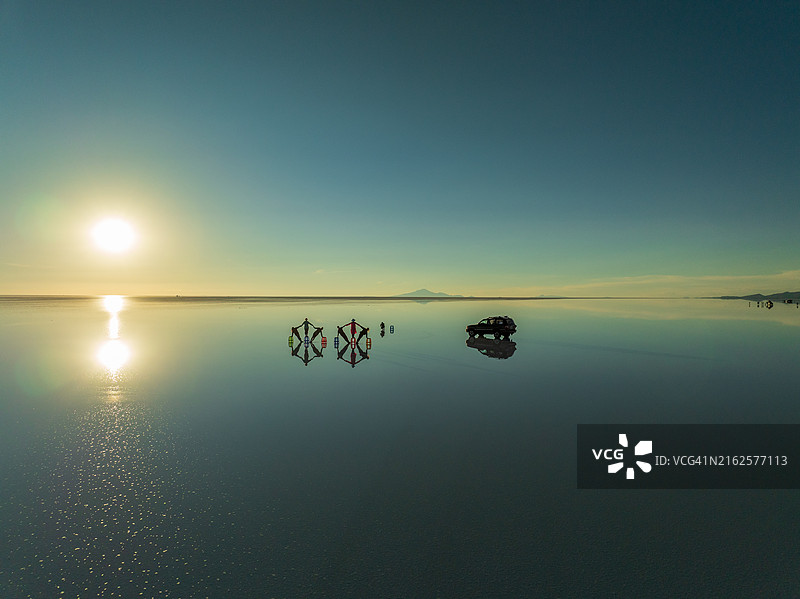 一群富有创意的人在乌尤尼盐沼中利用倒影创造形状图片素材