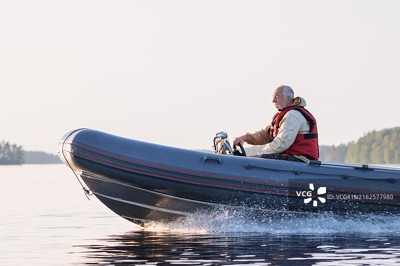 老年男人在湖上驾驶摩托艇图片素材