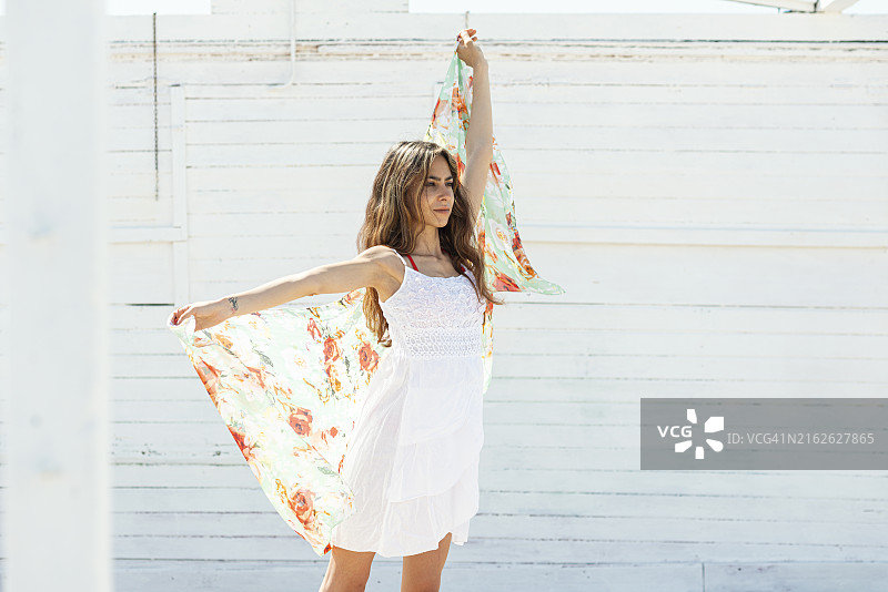 身穿太阳裙，玩弄花卉图案纱笼的女人图片素材