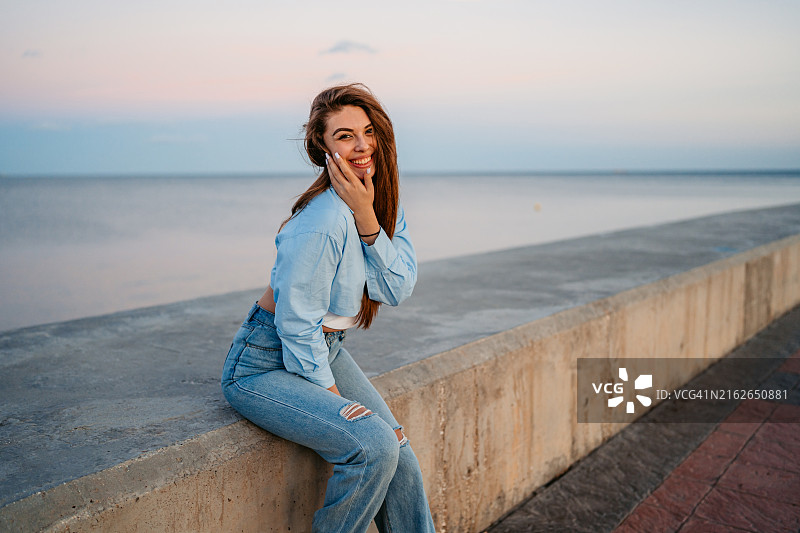 年轻女人坐在西班牙马拉加的码头上图片素材
