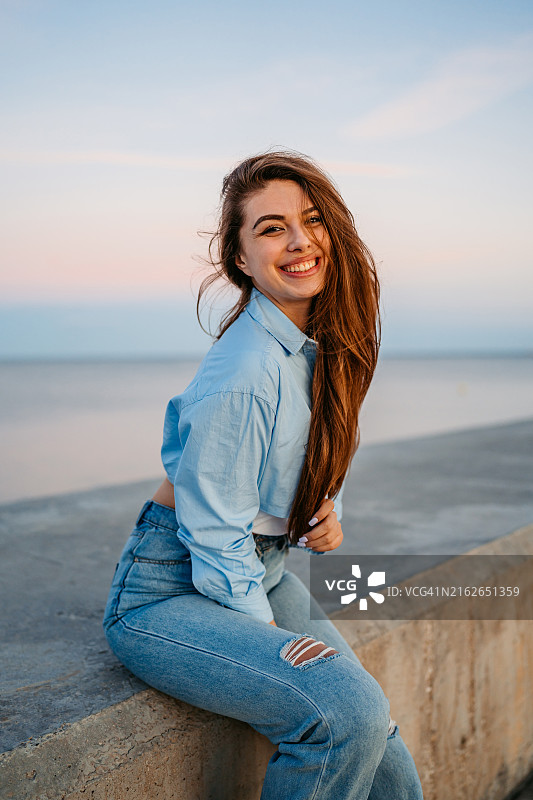 年轻女人坐在西班牙马拉加的码头上图片素材