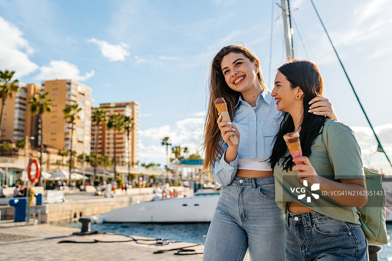 两位女性朋友在西班牙马拉加码头吃冰淇淋图片素材