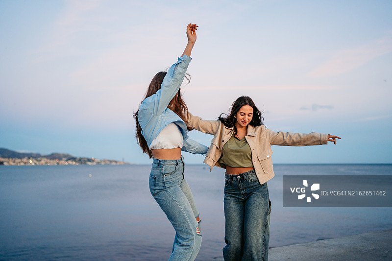 在西班牙马拉加码头跳舞的两位女性朋友图片素材