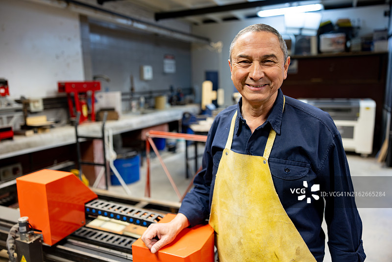 快乐的木匠在他的工作室工作图片素材