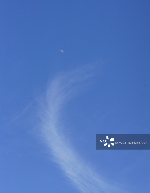 天空中带有白色云状尾巴的半月图片素材