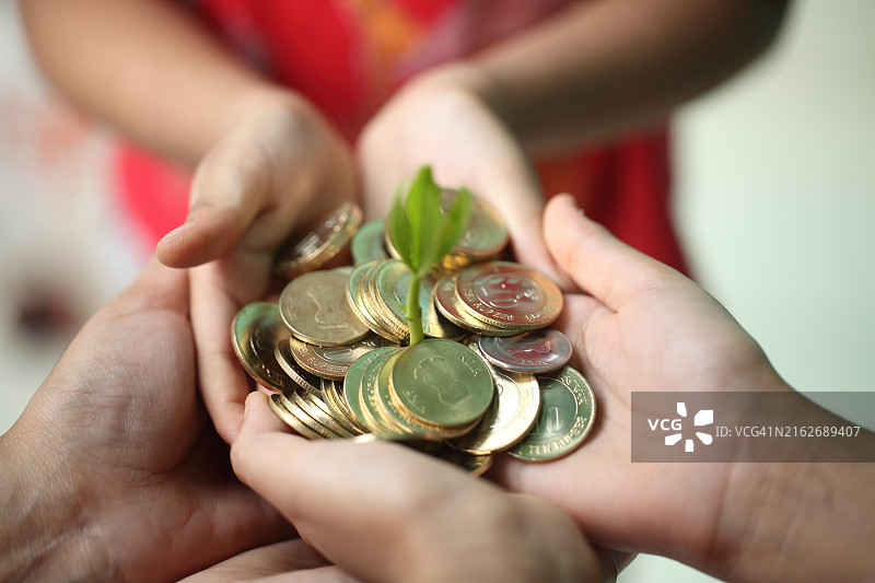 父母给孩子硬币和树苗-金钱增长理念图片素材