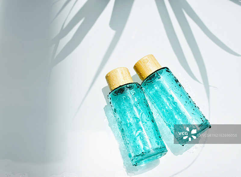 蓝色背景上的蓝色化妆品瓶图片素材