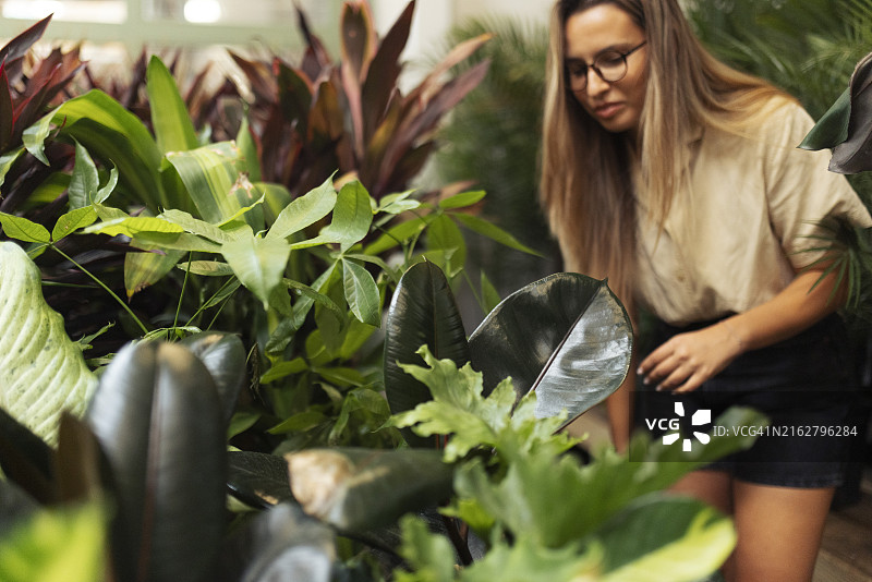 在园艺中心挑选和购买花盆的微笑女人图片素材