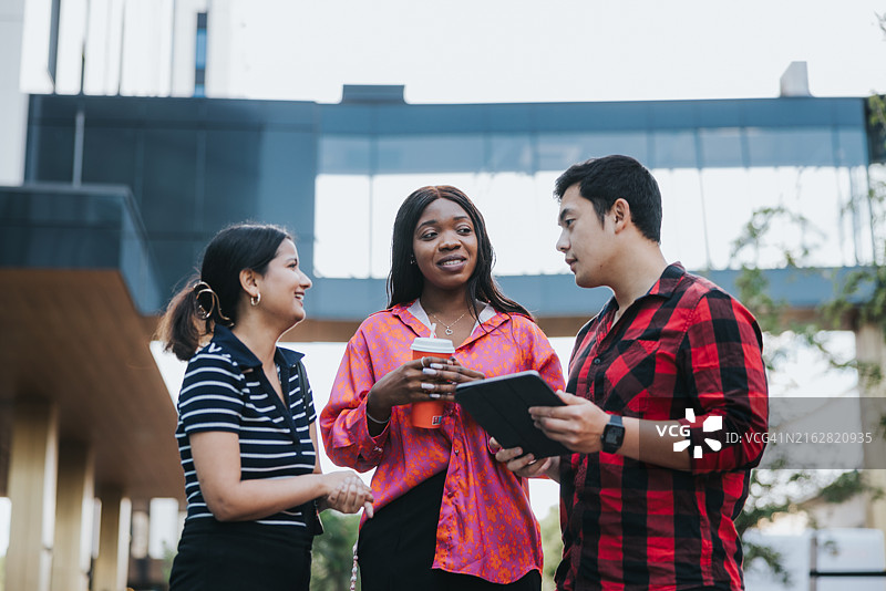 三位同事在办公室前进行户外简短会议图片素材