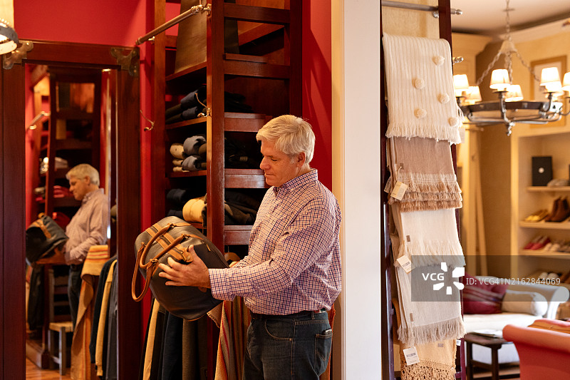 中年男人在商店里挑选和购买不同的服装图片素材