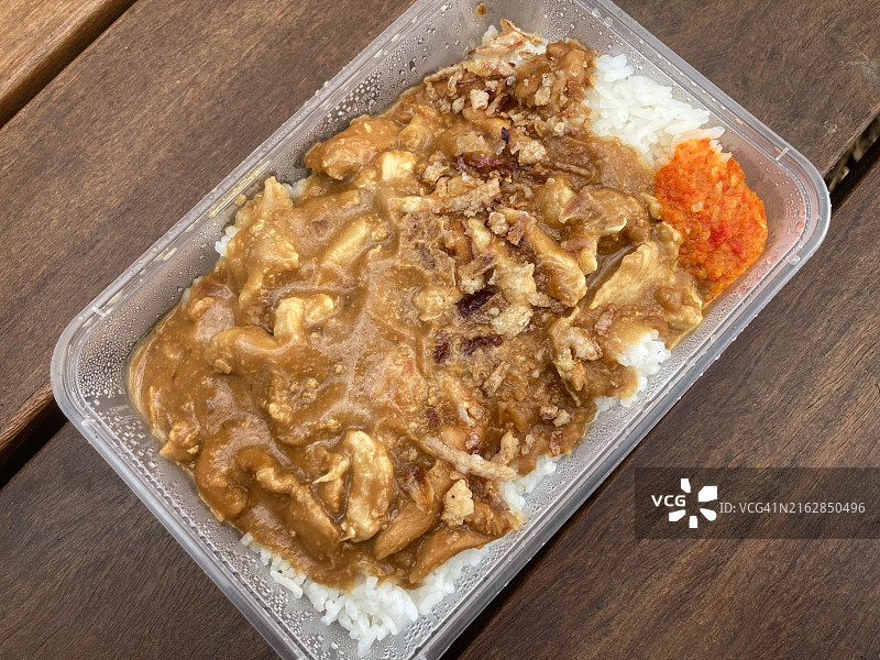 泰国鸡肉沙爹配米饭和辣椒酱，在户外桌子的塑料外卖容器中图片素材