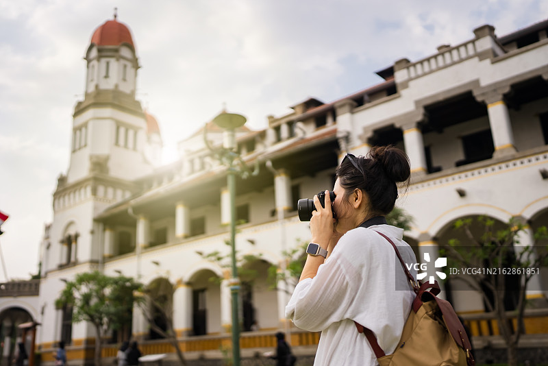 在三宝垄用相机拍摄Lawang Sewu荷兰车站的成年游客图片素材
