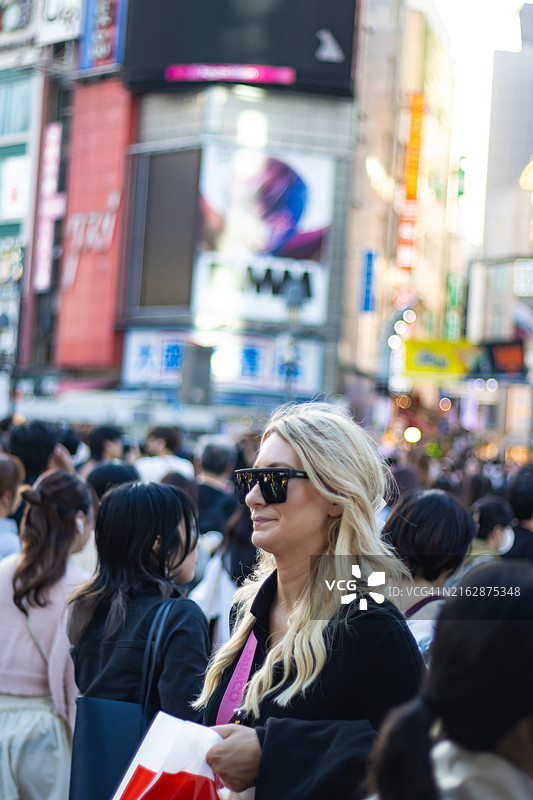 戴着太阳镜走在涩谷的女人图片素材