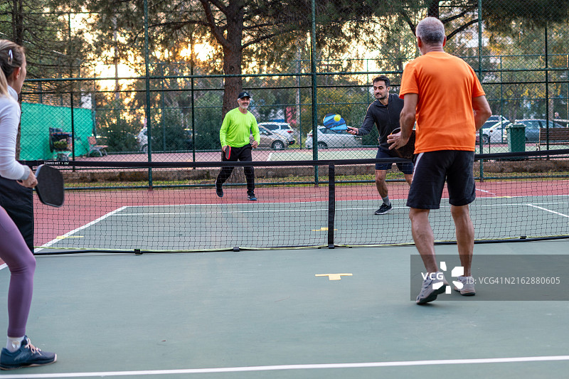 在硬地球场上打匹克球的女子图片素材