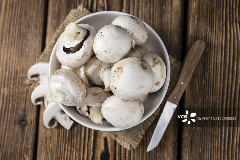 木质背景上的新鲜白色蘑菇图片素材