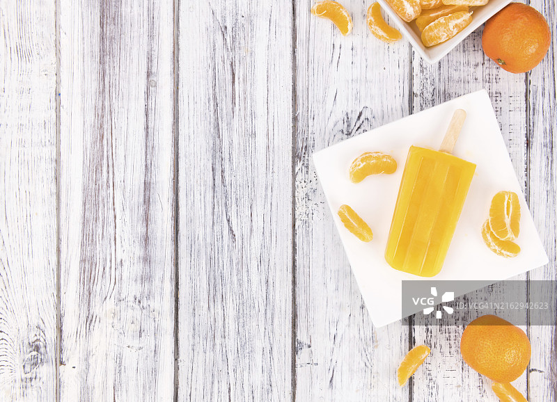 带有自制橘子冰棒的旧木桌（选择性聚焦，特写镜头）图片素材