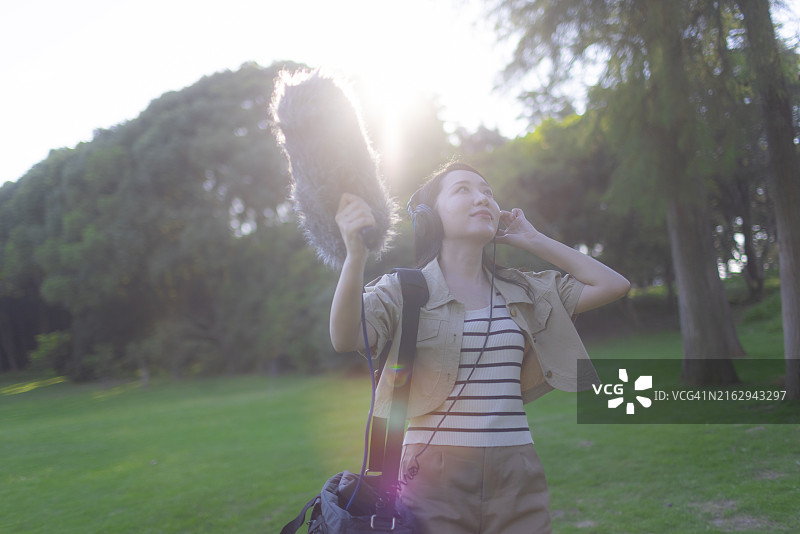 亚洲女性录音师使用枪式麦克风和挡风罩录制自然声音图片素材